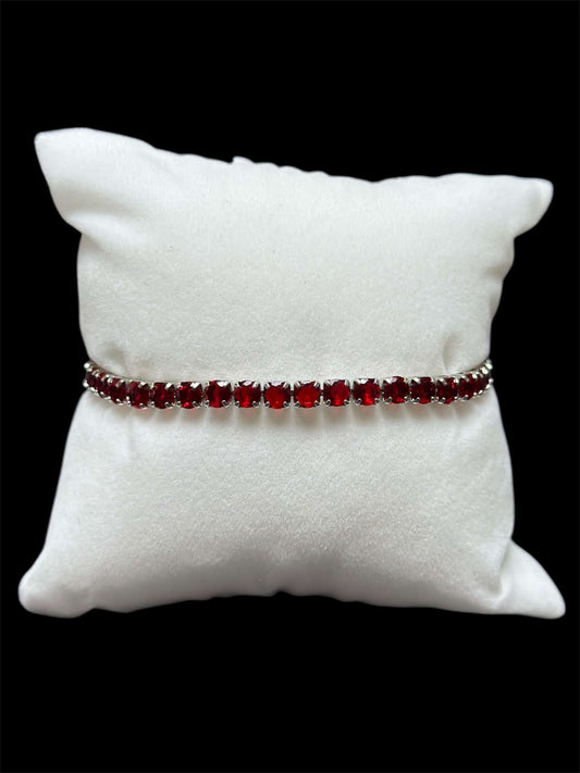 Pulsera Tenis Roja 3 mm Chapa Oro 14k sobre una almohadilla blanca suave.