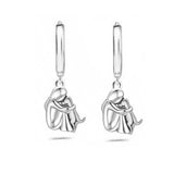 A little girl and a dog embrace earrings