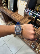 Reloj Ks Azul en acero inoxidable ajustable, visto en una muñeca, destacando su diseño moderno y atractivo.