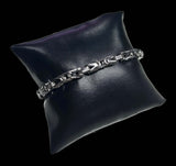 Pulsera 6 mm acero inoxidable sobre cojín negro, diseño elegante en acero inoxidable quirúrgico.