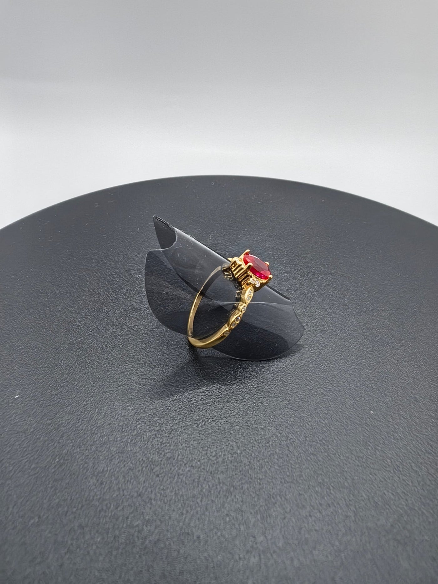 Anillo Plata Esterlina 925 Chapa Oro 10k Calenbi en un soporte negro con un detalle en forma de gema roja.